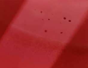 Rubino sintetico al microscopio: si notano strie di accrescimento curve e minute bolle di gas